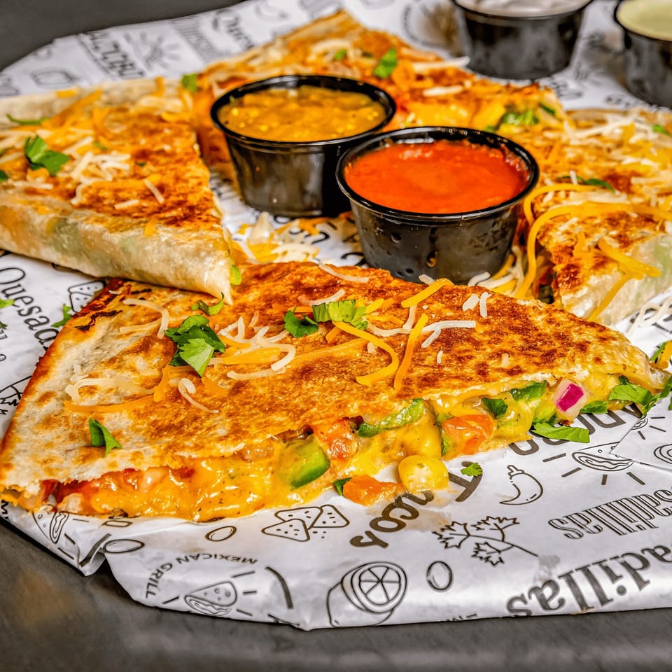 Taco Express Mexican Grill quesadillas with melted cheese, vegetables, and two dipping sauces.